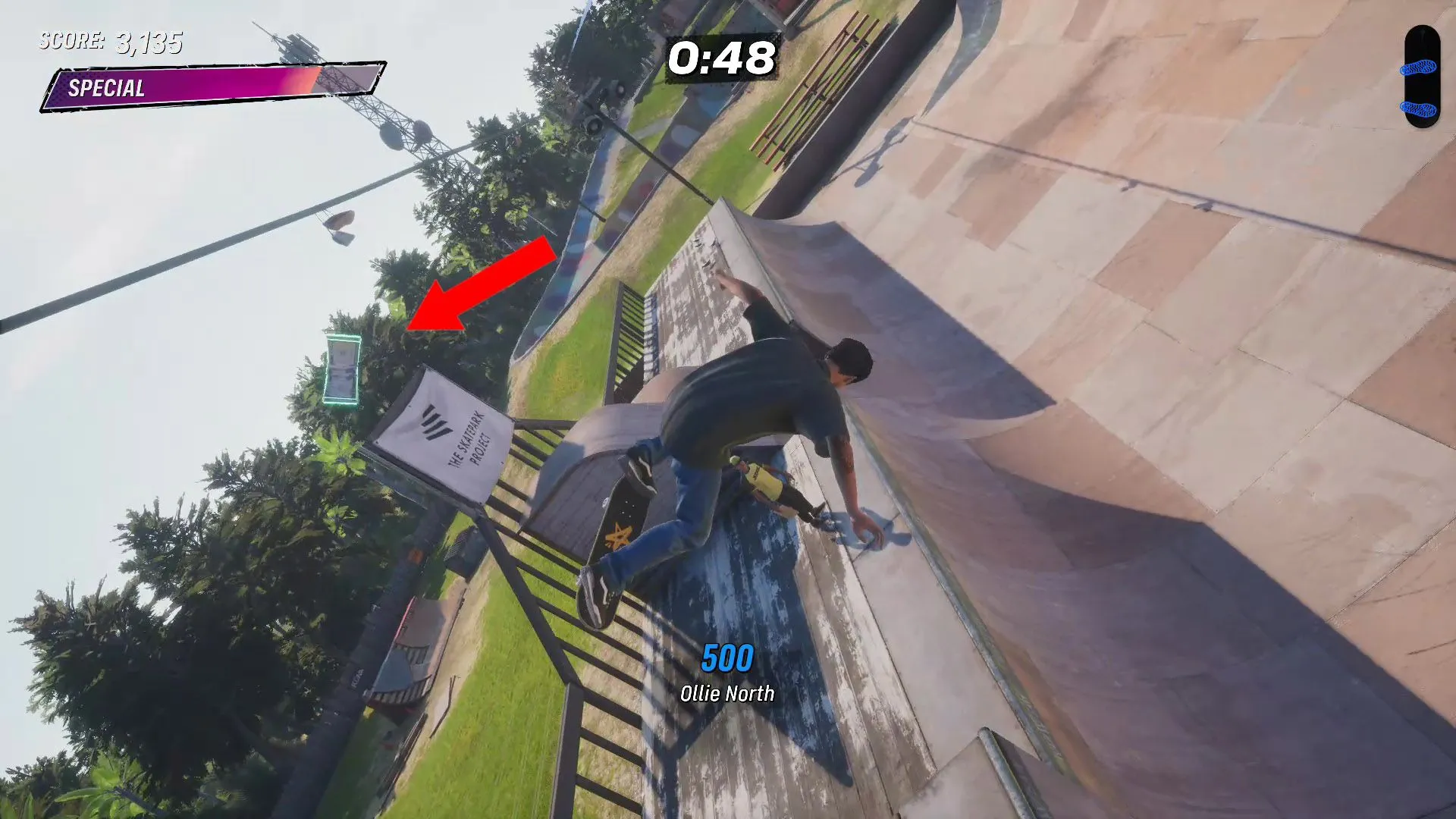 Cọc tiền Cash thứ ba lơ lửng trên halfpipe, phía trên biển báo The Skater Park Project tại Kona