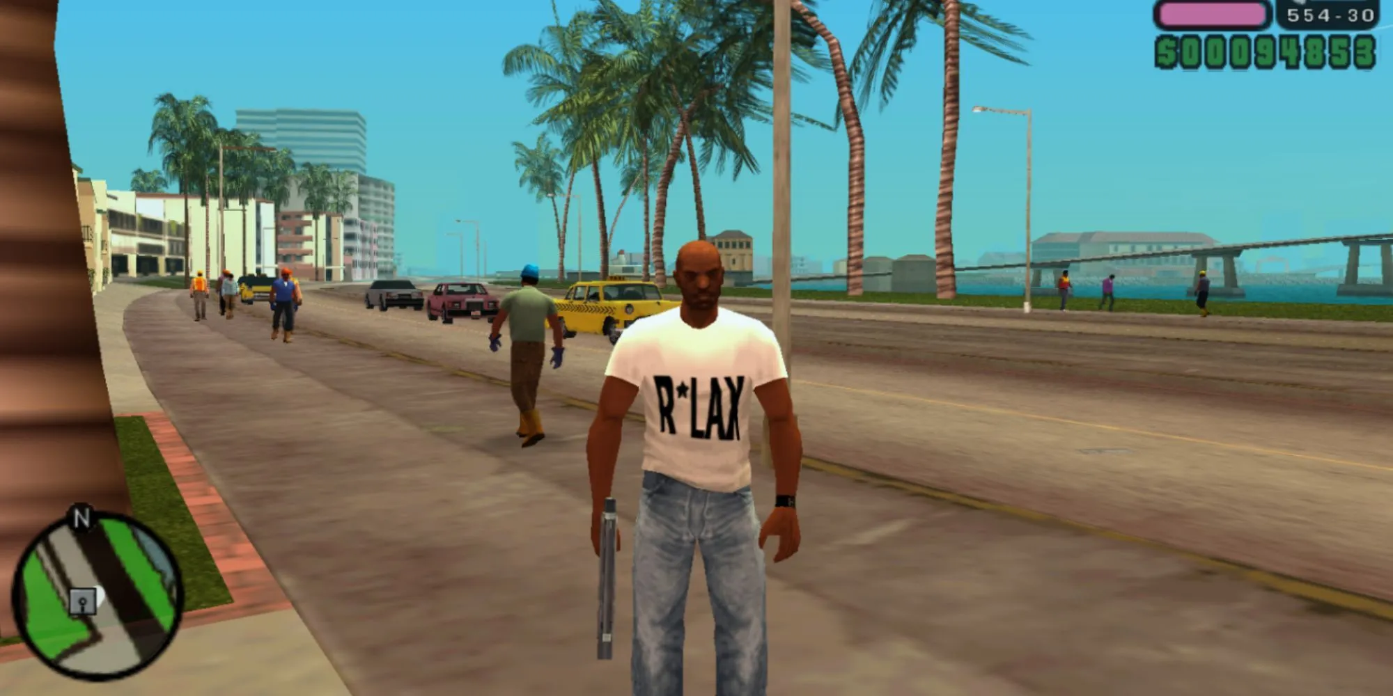 Victor Vance cầm súng đứng trên bãi biển của Vice City trong Grand Theft Auto: Vice City Stories, thể hiện không gian mở rộng lớn của game trên PSP